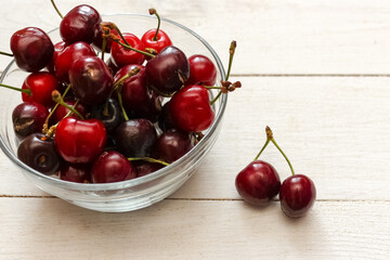 sweet red cherries in a plate on a wooden table