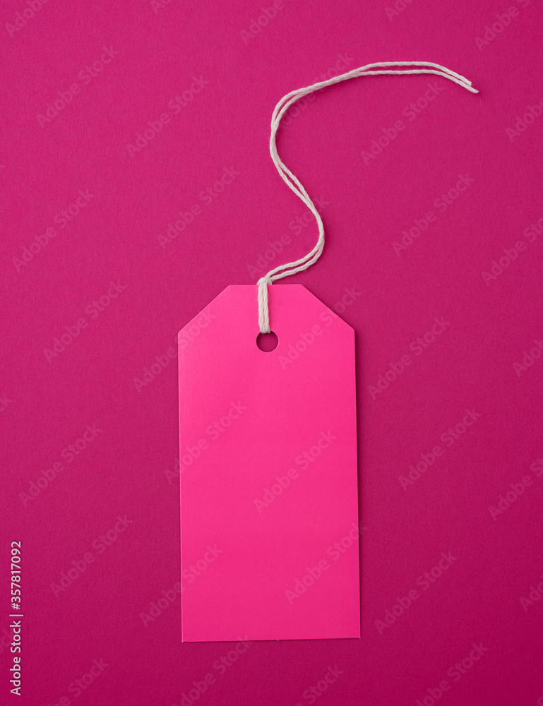 Poster empty pink paper rectangular tag on a rope on a pink background
