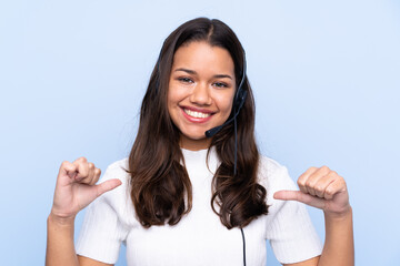 Young telemarketer Colombian woman over isolated blue background proud and self-satisfied