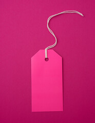 empty pink paper rectangular tag on a rope on a pink background