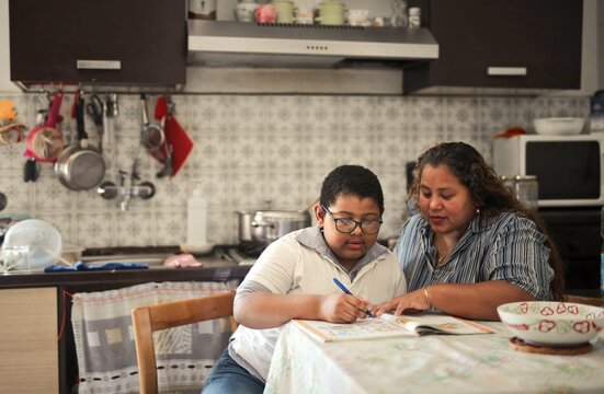 mother helps her son with schoolwork