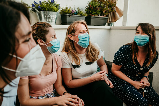 .Happy Group Of Young Girlfriends Meeting After The Quarantine Caused By The Covid Pandemic19. Taking Caution With The Use Of Surgical Masks. New Normal.