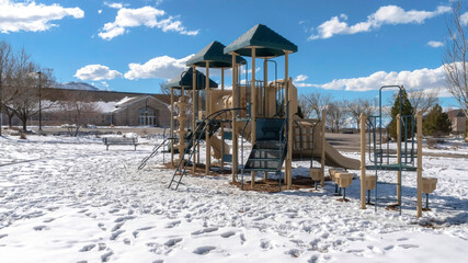 Panorama Park playground amid footprints on sunlit snow covering the ground in winter