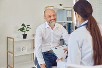 A middle-aged man talks to a doctor in the office. Medical consultation diagnosis prescription in a hospital