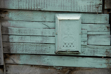 Old painted mail box on a wooden green wall