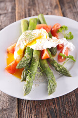 asparagus with poached egg and tomato in plate