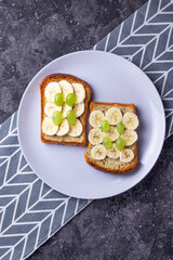 Crispy toast with banana and grape on a gray background healthy meal