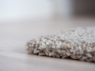 Image of white carpet on the light wooden parquet floor
