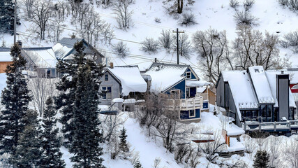 Panorama crop Park City mountain slope with houses amid fresh snow and evergreens in winter
