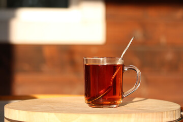 A cup of tea with Spoon on the wooden table in the garden
