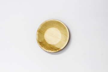 Round Areca Leaf Bowl, eco-friendly disposable cutlery. Top view on a white background.