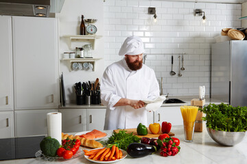 Portrait of mature chef in uniform prepare his kitchen 