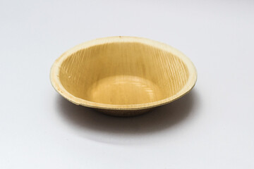 Round Areca Leaf Bowl, eco-friendly disposable cutlery. Side view on a white background.