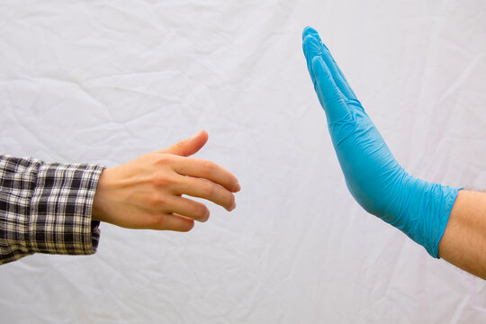 social distancing concept stop sing by hand in blue latex glove health care global pandemic crisis on white rustic background with empty copy space for your text