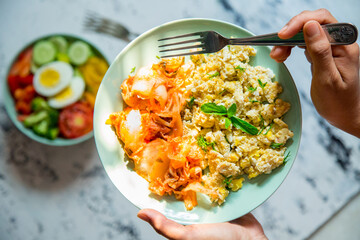 Scrambled Egg and Kimchi along with a Bowl of Salad. Top View. Paleo Breakfast.