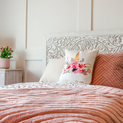 Square crop Bedroom with feminine beddings and decorative headboard against panelled wall