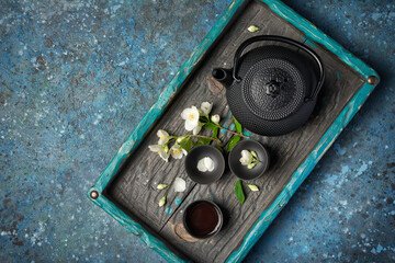 Asian black traditional teapot and teacups with healthy jasmine tea