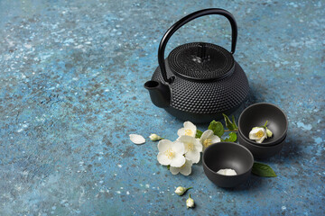 Asian black traditional teapot and teacups with healthy jasmine tea