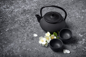 Obraz na płótnie Canvas Asian black traditional teapot and teacups with healthy jasmine tea