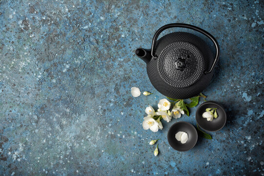Asian black traditional teapot and teacups with healthy jasmine tea
