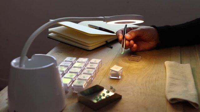 Gemologist working at your table with different jewelry tools. Precious stones.