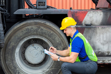 Mechanics checking wheel in cargo container. Professional technician pre-check forklift truck...