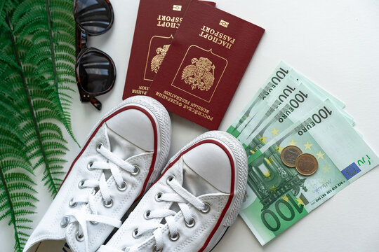Travel accessories are photographed from above. Set for a comfortable stay with sneakers, money and passport