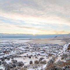 Square Snowy Eagle Mountain Utah landscape with homes lake and mountain in winter