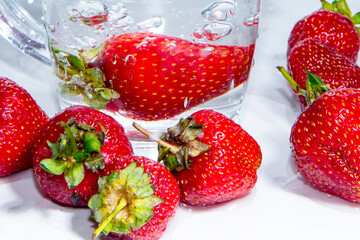 Strawberries in a mug with water with bubbles close-up