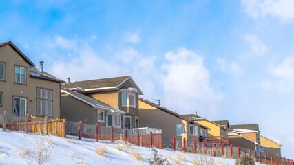 Fototapeta na wymiar Panorama crop Wasatch Mountain residential area with homes against clouds and blue sky