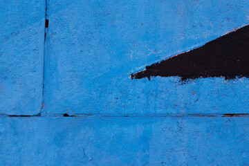 The texture of cracked blue and black paint on a brick wall was shot closeup. There is a place for text.