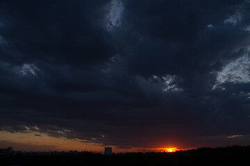 dark clouds orange sun set black sillhoutte vertical