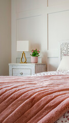 Vertical crop Bedroom with feminine beddings and decorative headboard against panelled wall