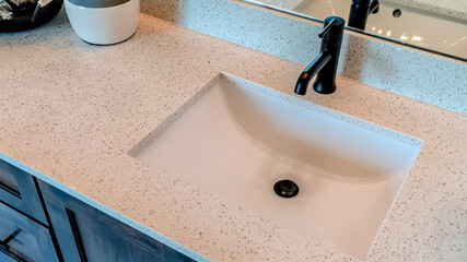 Panorama Single basin undermount sink with black faucet on white countertop over cabinet