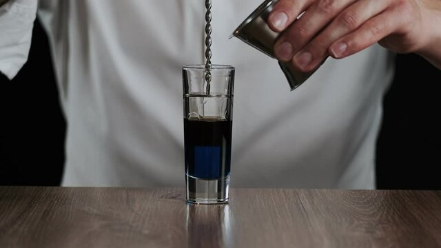 Preparing of Lexus Cocktail. Close up pouring sambuca into a glass
