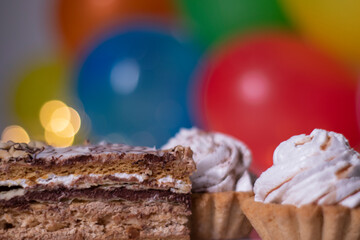 festive cupcake on the background of multi-colored balloons and lights. party, birthday concept. Copy space. High quality photo