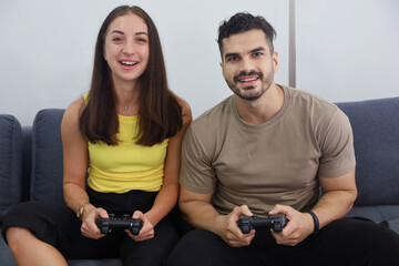 A couple love or friend funny play and enjoy with a controller of joystick vedio game together, freetime lifestyle