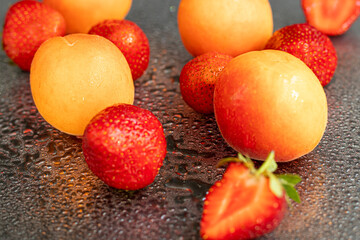 Large ripe strawberries are collected from the garden. On a black wooden background. Homemade...