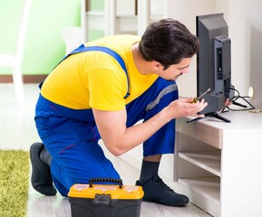 Male professional serviceman repairing tv at home