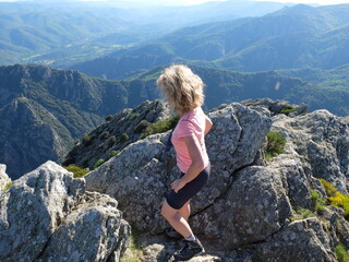 jeune femme blonde devant le vide de la montagne du Caroux au soleil couchant du parc naturel du haut languedoc