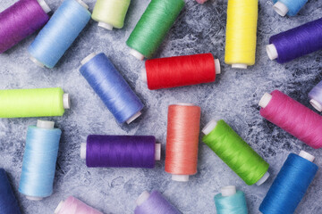 Black and white background with colorful threads on bobbins.