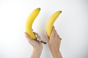 image of woman's hands holding fresh bananas on isolated white background