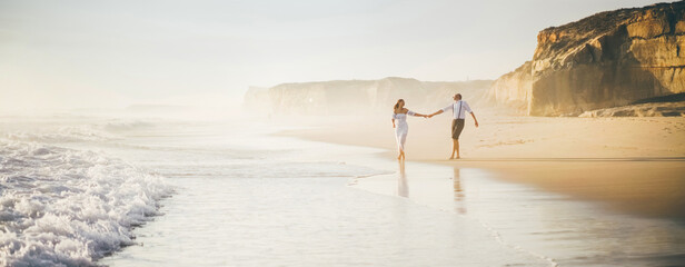 Man and woman have fun on the beach. Couple in love running at the beach.