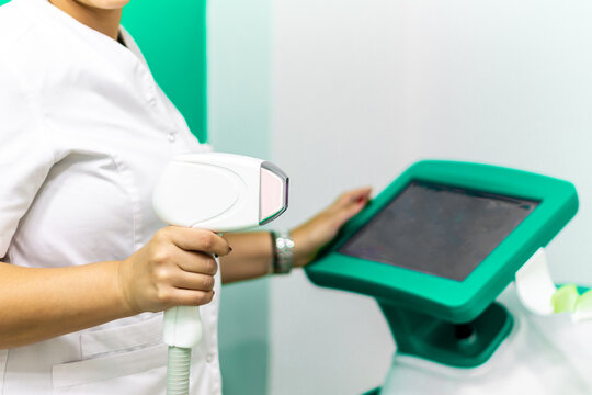 hand holding laser depilation machine in clinic with white coat, clinical laser depilation