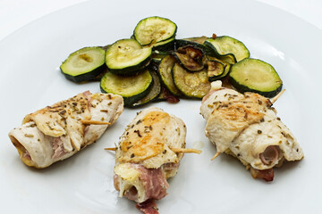Roll Chicken Fillet (chicken involtini) and zucchini in a white dish.