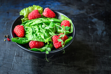 salad raspberries and lettuce, spinach, arugula Menu concept serving size. food background top view copy space for text organic healthy eating keto or paleo diet