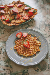 Breakfast with waffles, honey and strawberries