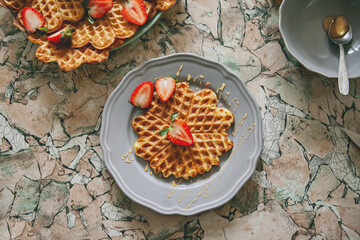 Breakfast with waffles, honey and strawberries