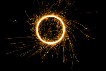 Happy New Year colored sparkling circle from a burning sparkler on black background. Holiday concept, background