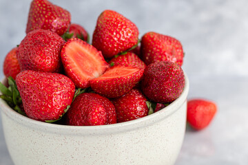 Large ripe strawberries are collected from the garden. On a gray stone background. Homemade winter...